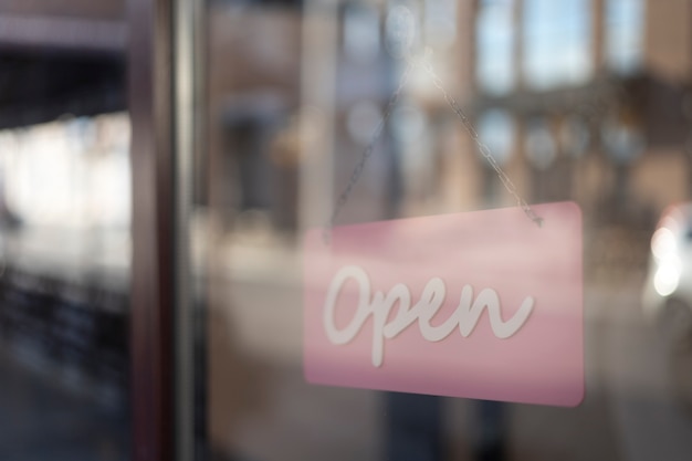 Free photo open pink sign behind window