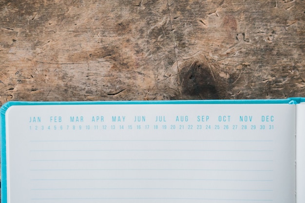 Free Photo opened blue textbook with date markers on top on a wooden surface