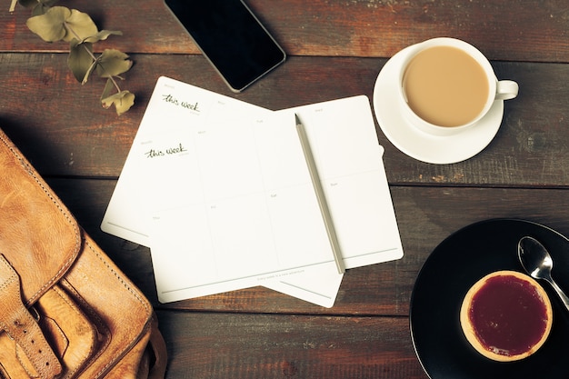 Free photo opened craft paper envelope , autumn leaves and coffee on wooden table