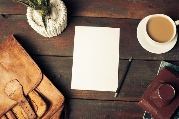 Opened craft paper envelope , autumn leaves and coffee on wooden table