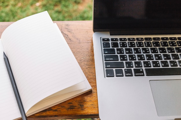 Opened notebook near laptop on shelf