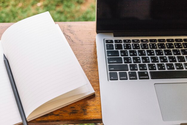 Opened notebook near laptop on shelf