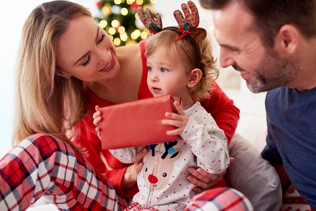 Opening Christmas present with parents in bed