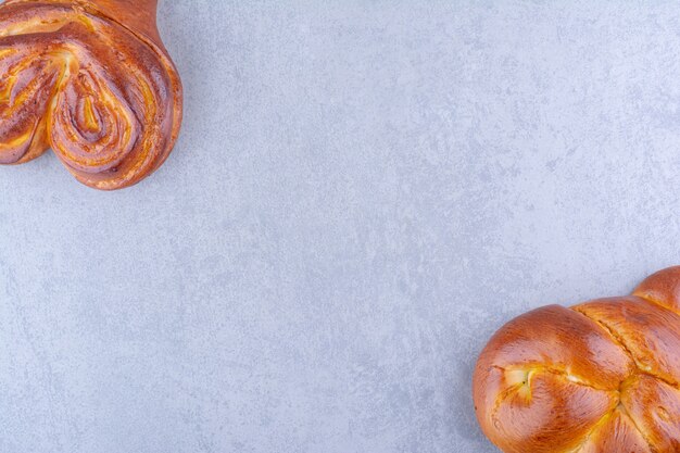 Oppositely arranged sweet heart buns bundled together on marble surface