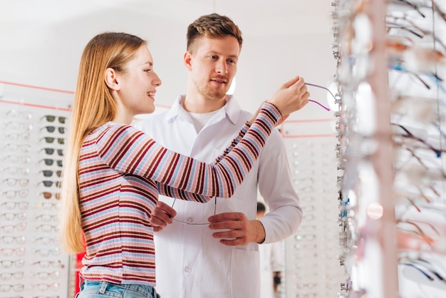 Optometrist advising woman choosing glasses