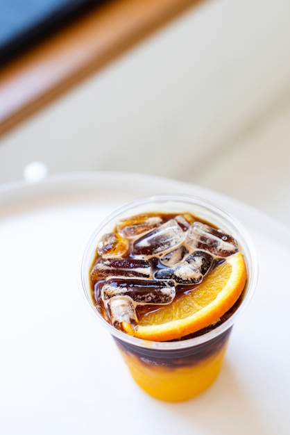 Free photo orange americano iced coffee at a cafe aerial view