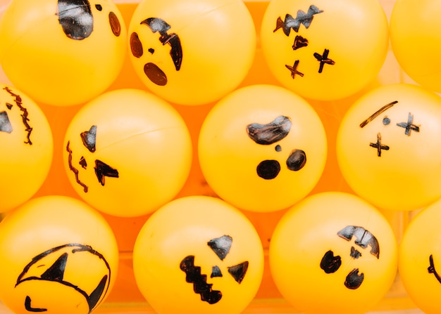 Free photo orange balls with painted spooky faces