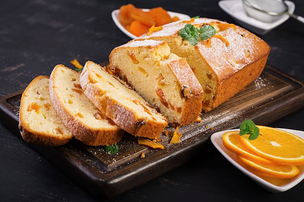 Orange cake with dried apricots and powdered sugar.