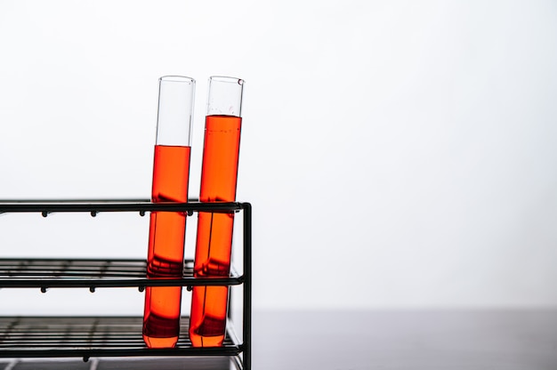 Free photo orange chemicals in a science glass tube arranged on a shelf