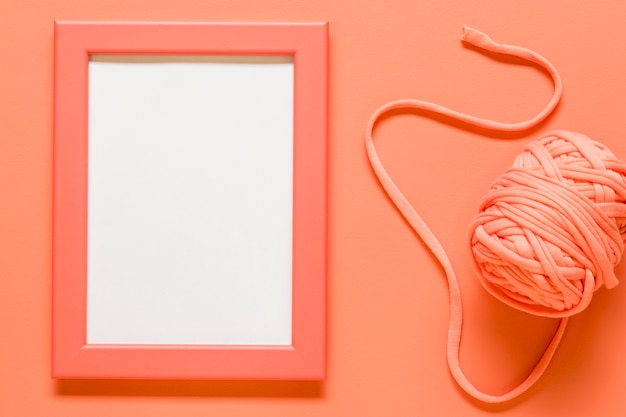 Free photo orange empty frame and ball of rope