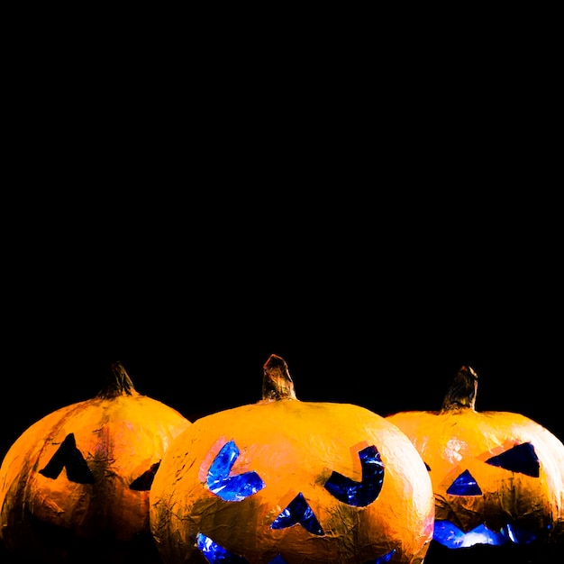 Free photo orange handmade pumpkins with carved faces in halloween style