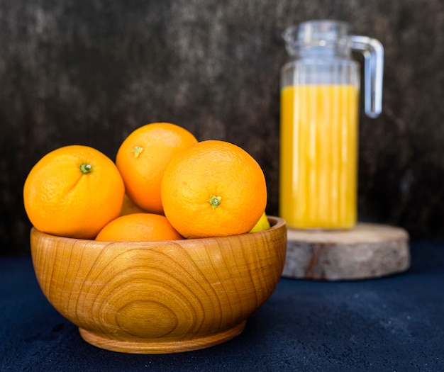 Free photo orange juice and pile of oranges in bowl