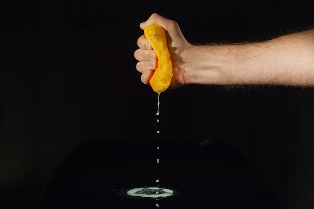 Free photo orange juice splashes from half of fruit in man's hand