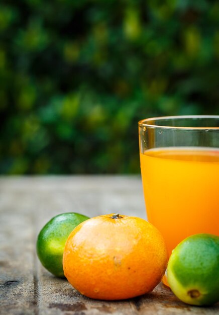 Orange juice with lemon lime and mint on a wooden board