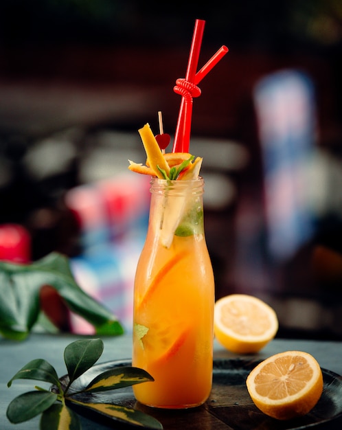 Free Photo orange juice with orange slices and red pipes in bottle