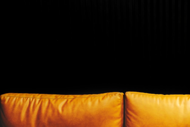 Free Photo orange leather sofa against a black wall