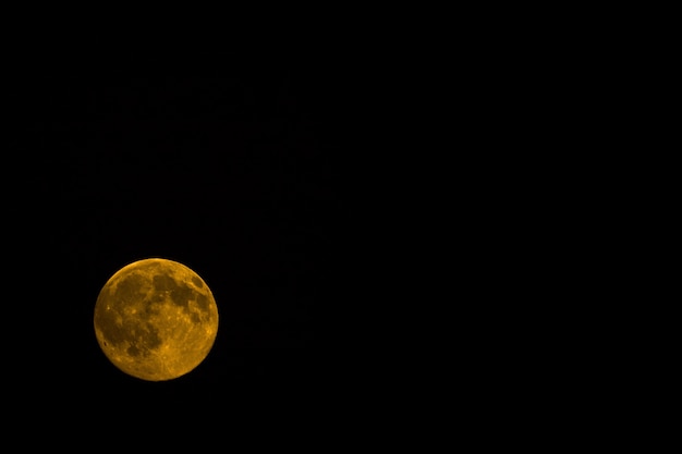 Free Photo orange moon at night isolated on a black