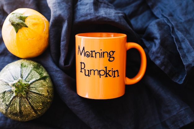 Free Photo orange mug and pumpkins