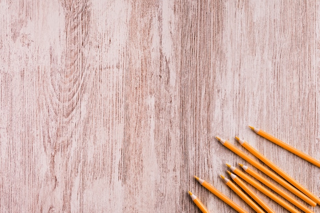 Orange pencils on wooden surface