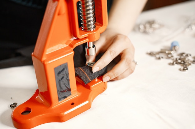 Orange press for clothes. Buttons on fabric. Woman with sewing tools