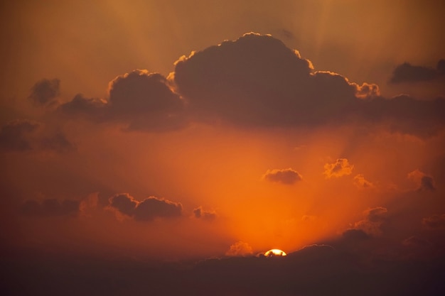 Orange sky with clouds and sun