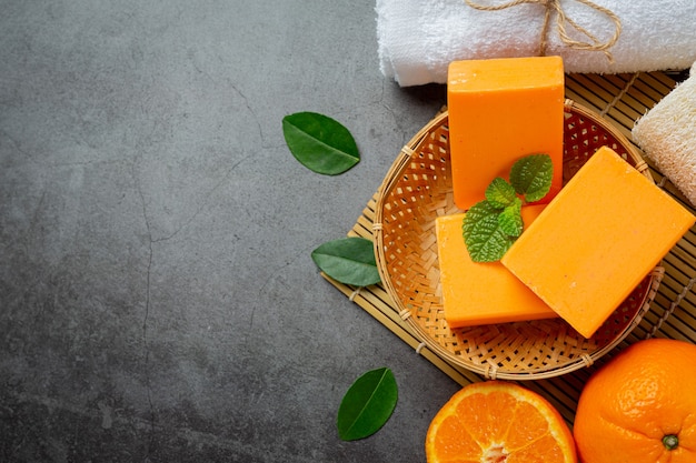 Orange soap with fresh orange on dark background