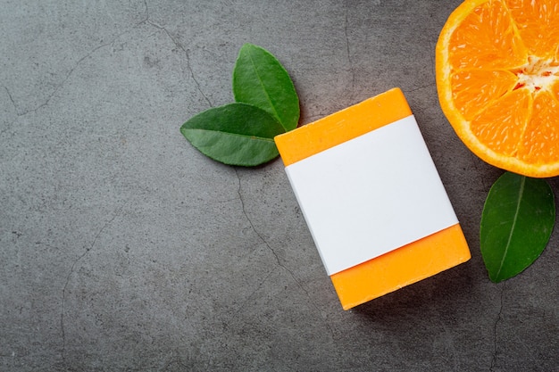 Orange soap with fresh orange on dark background