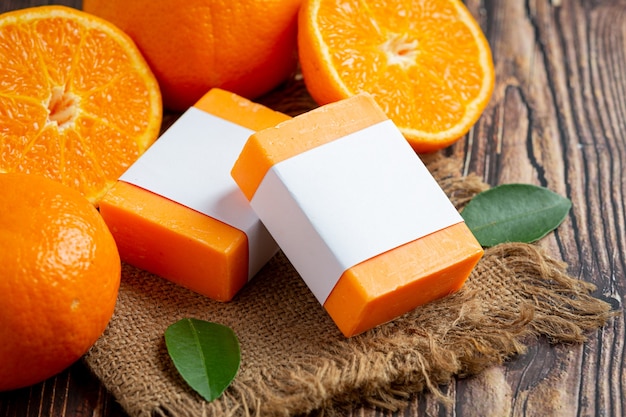 Orange soap with fresh orange on dark wooden background