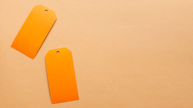 Free photo orange tags on neutral carboard sheet with copy space