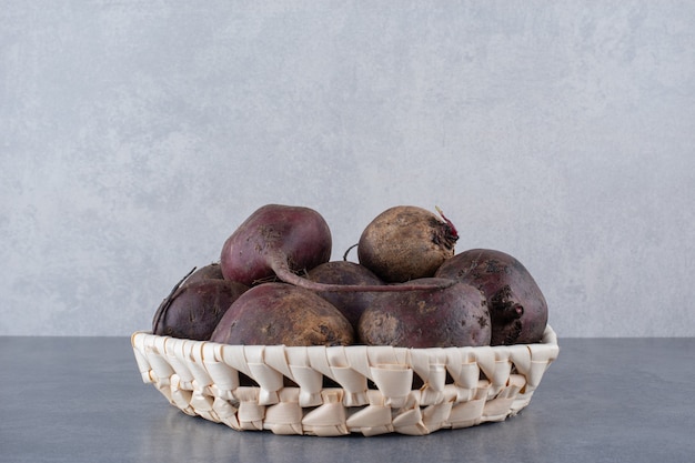 Free photo organic beetroots isolated in a wooden platter on concrete surface