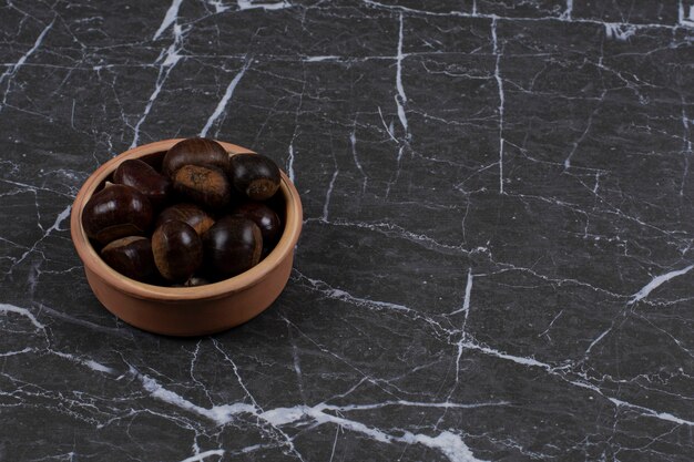 Organic chestnut in the bowl, on the marble surface