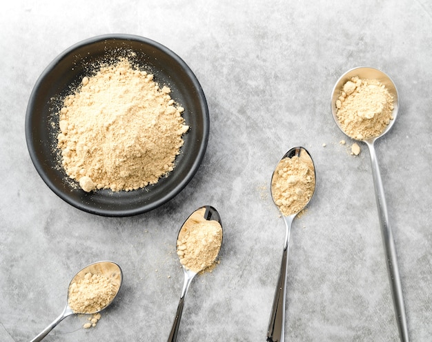 Organic food powder in bowl and spoons