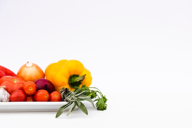 Free photo organic fresh vegetables in tray isolated on white background