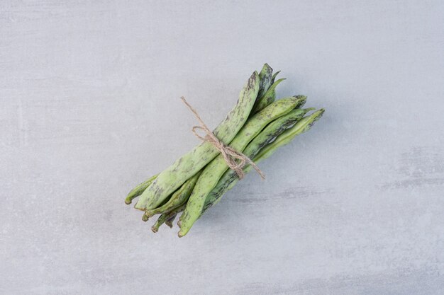 Organic green beans tied with rope on stone surface. High quality photo