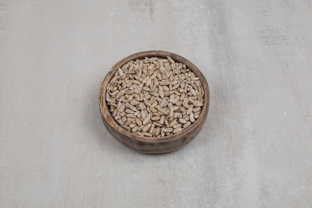 Organic sunflower seeds in wooden bowl.