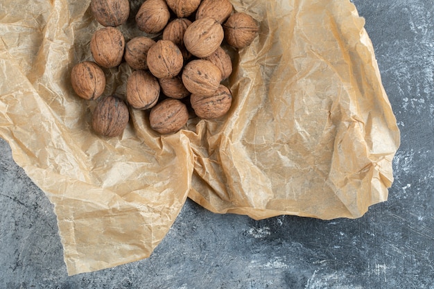 Free Photo organic walnuts on brown paper sheet. 