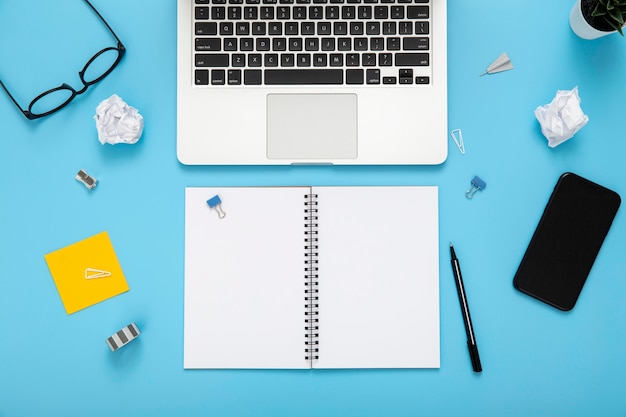 Organised arrangement of desk elements on blue background