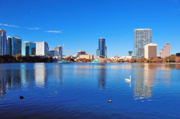 Orlando Lake Eola in the morning with urban skyscrapers and clear blue sky with swan.