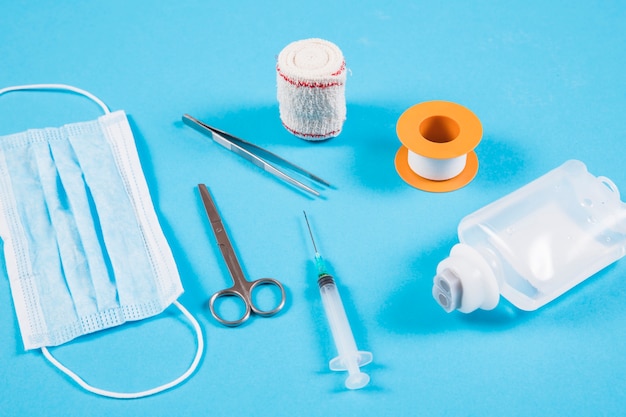 Free photo orthopedic bandage; tweezers; mask; syringe and iv bottle on blue background