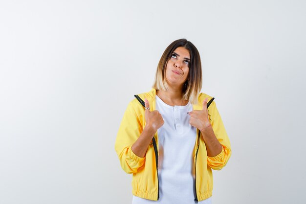 Ortrait of female pointing at herself in t-shirt, jacket and looking hesitant front view