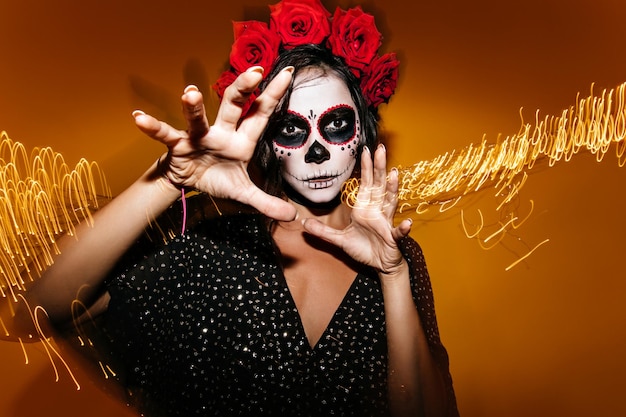 �oseup shot of brunette with crown of red roses Lady in nonhalloween outfit poses for portrait