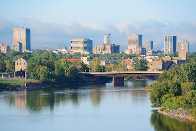 Ottawa cityscape in the day over river with historical architecture.