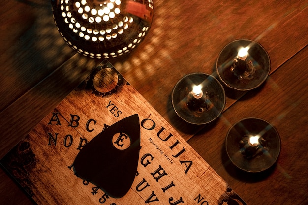 Ouija board and candles arrangement flat lay