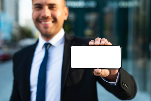 Free photo outdoor businessman showing a copy space phone