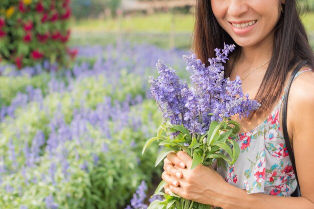 outdoor portrait of a beautiful middle aged asia woman. attractive girl in a field with flowers