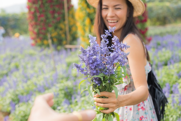 outdoor portrait of a beautiful middle aged asia woman. attractive girl in a field with flowers