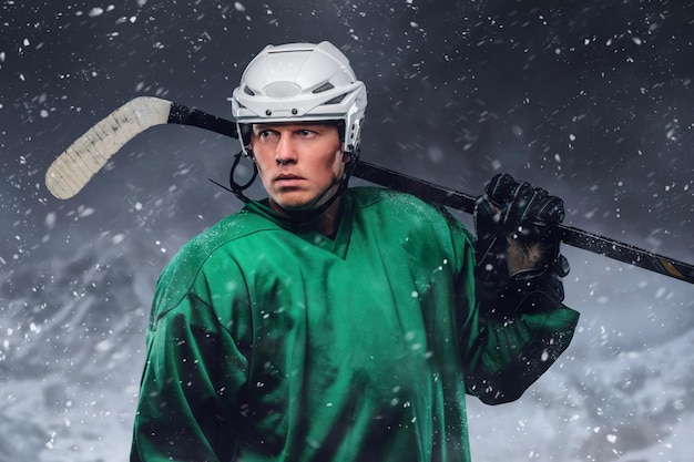 Free photo outdoor portrait of professional hockey player in a snow storm.