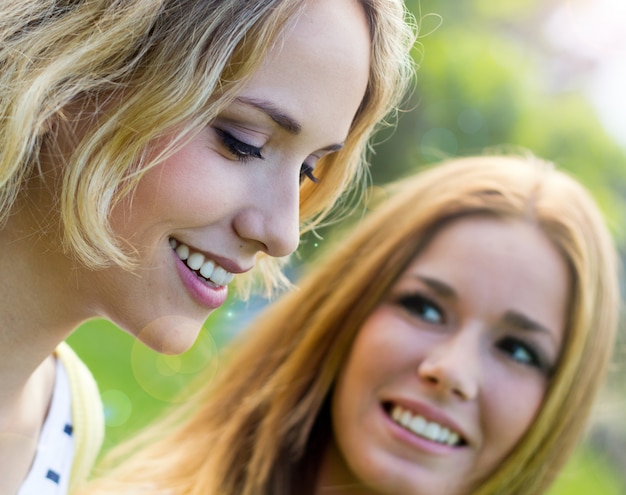 Free photo outdoor portrait of two beautiful young womens posing at the park