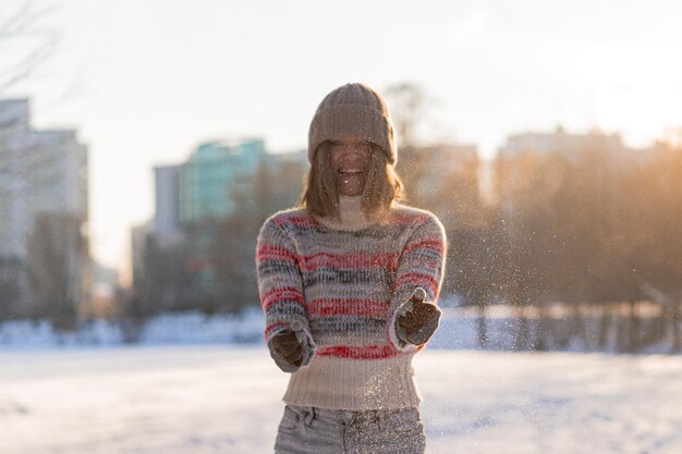 Outdoor portrait of young beautiful fashionable happy smiling woman winter portrait, woman in winter hat, snow. enjoying winter moments