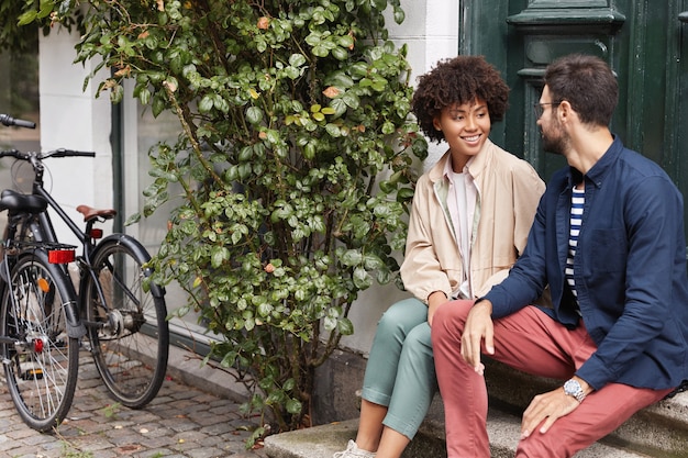 Outdoor shot of couple sitting on the stairs of cafe